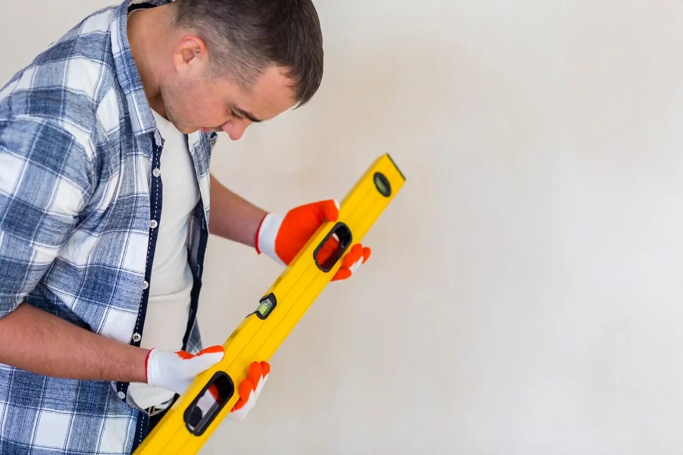 A man looks down at a spirit level.