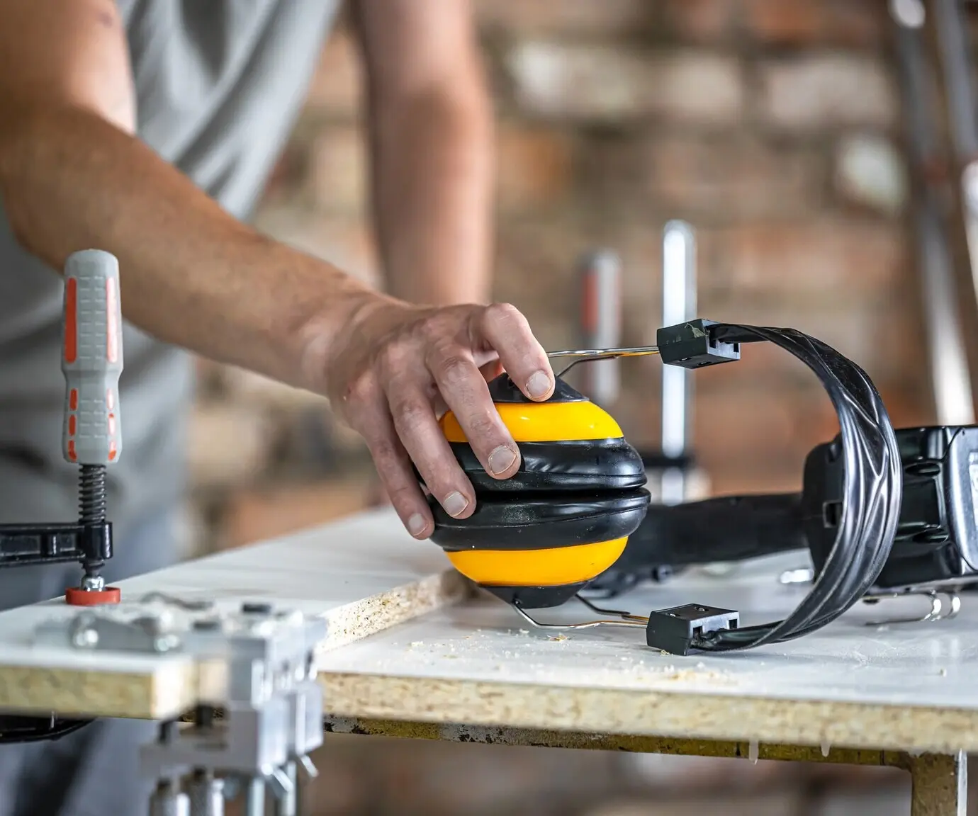 Professional carpenter’s workplace featuring protective headphones, personal protection for work at a woodwork production workshop.